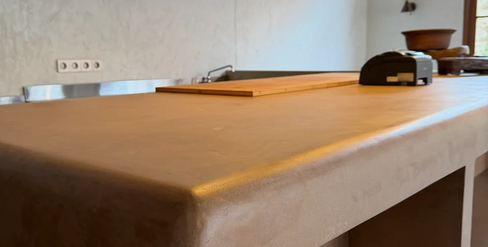 A kitchen with microcement countertops and island.